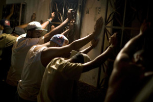 Un grupo de sospechosos son registrados por agentes de policía durante una redada en Petare, Caracas. (Reuters) 